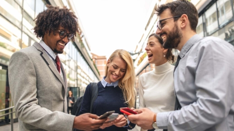 Photo of 4 agents on cell phones in a group